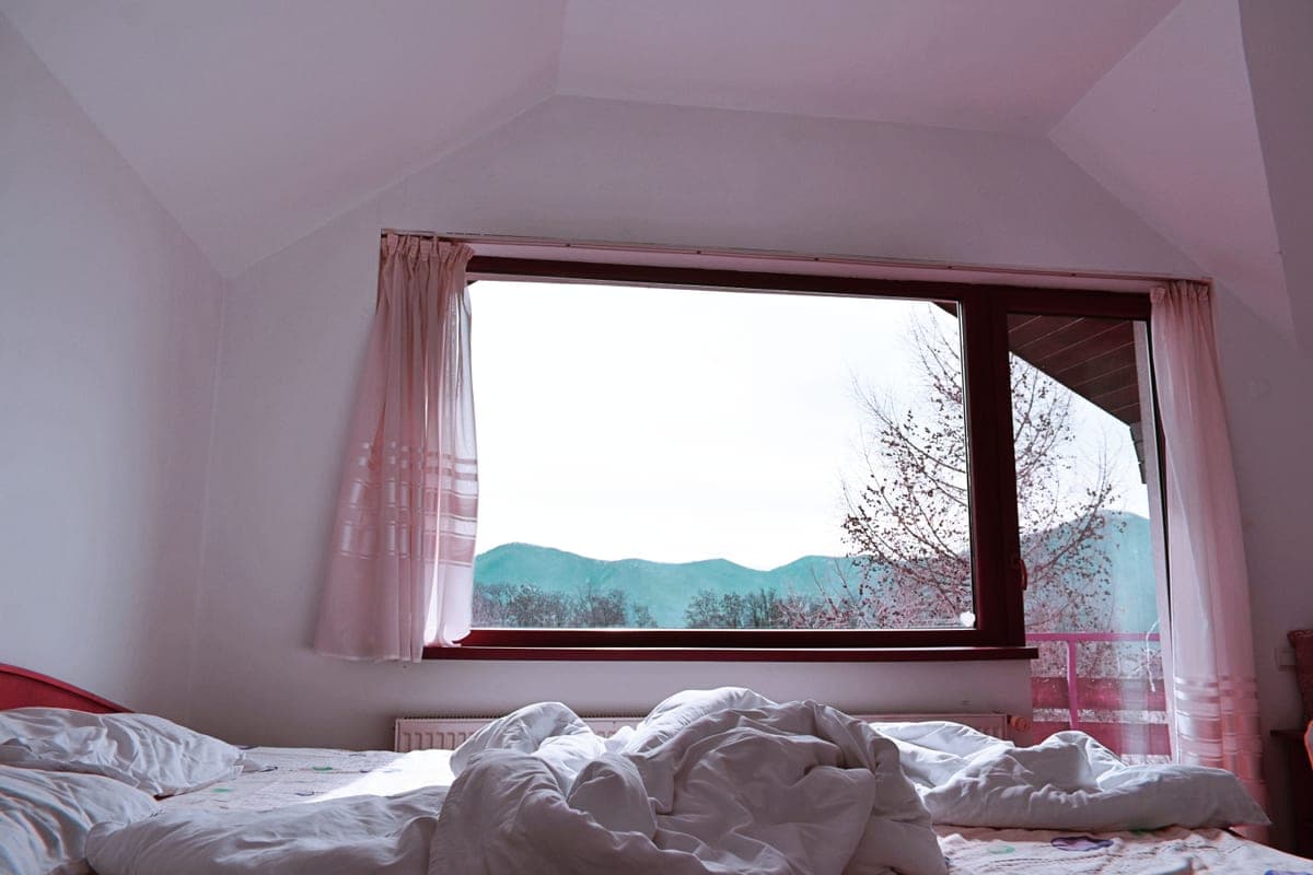 A cozy bed with a thick blanket in morning light