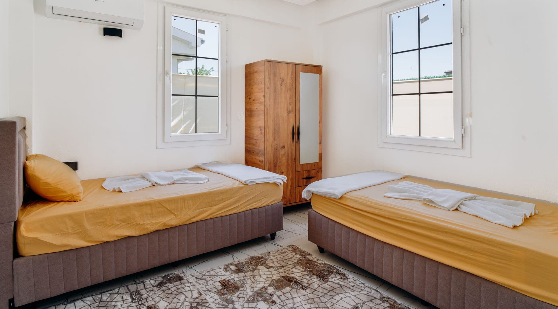 A minimalist bedroom with two neatly made single beds