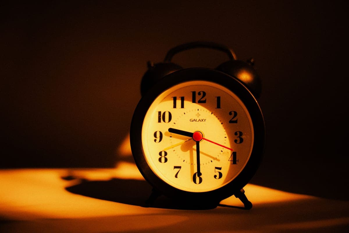 A bedside clock in a dark room at night