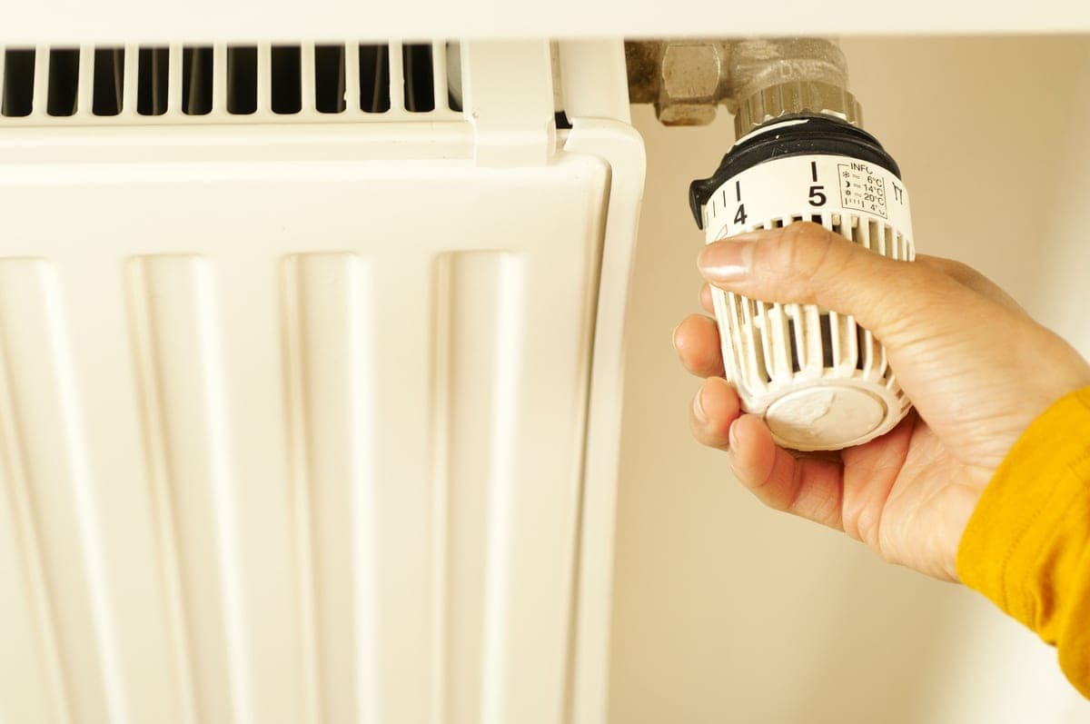 A wall-mounted thermostat and radiator in a home