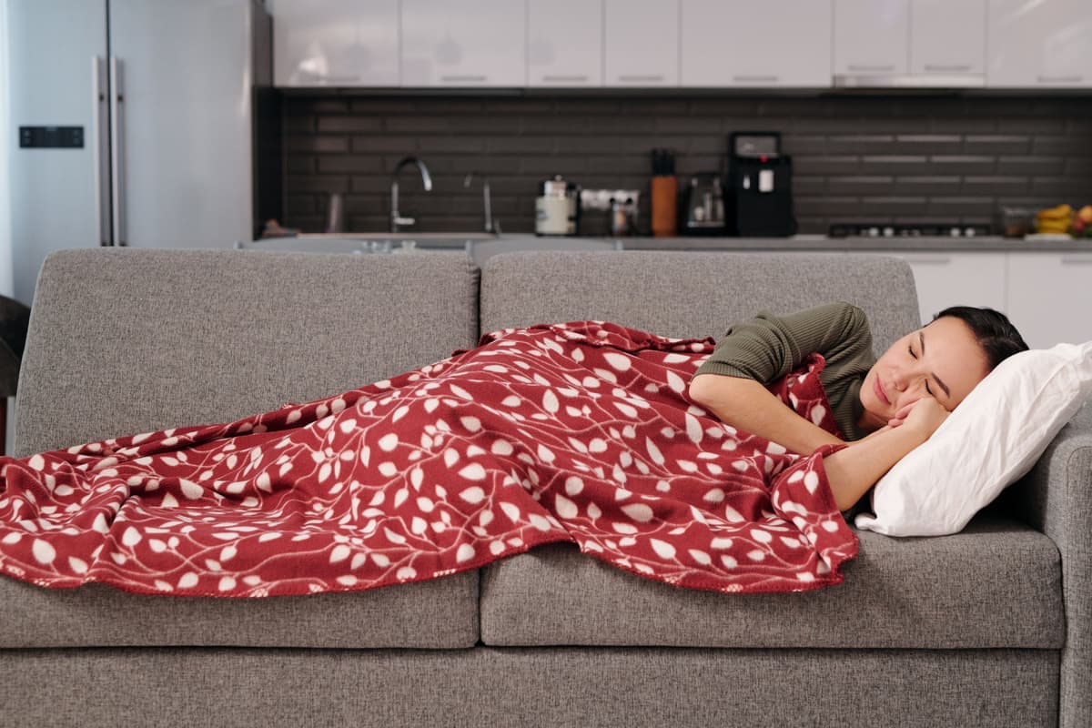 A person wrapped in a blanket on a couch