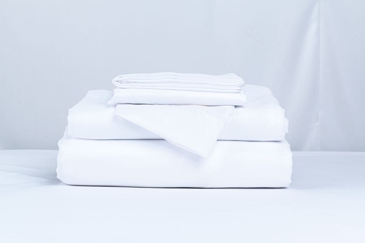 A folded stack of clean bed linens