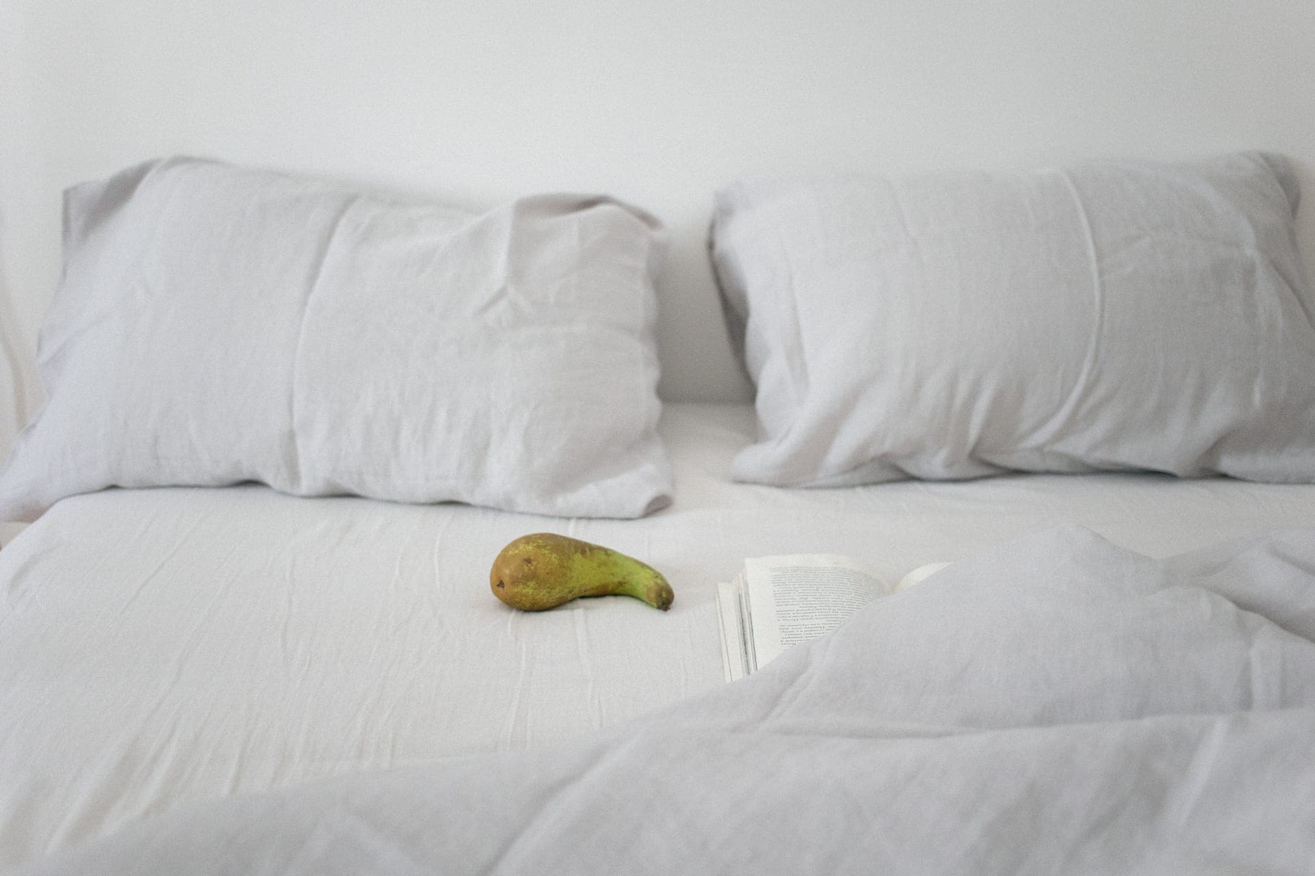 A neatly made bed with the covers turned back at one corner