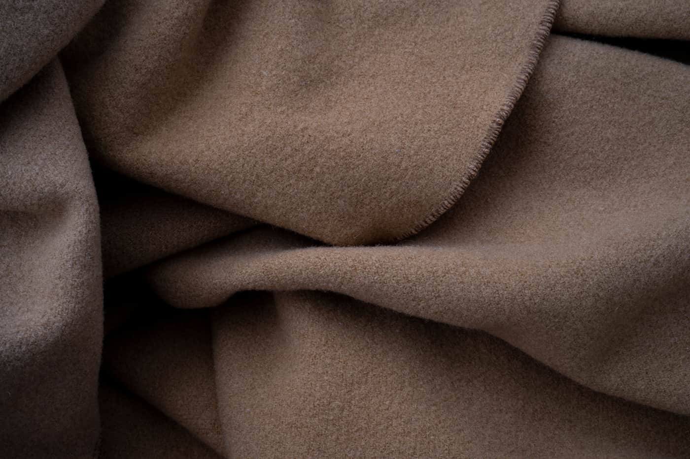 Two folded blankets side by side on a neutral surface